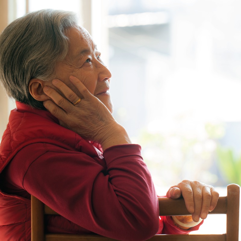 Senior woman sitting in a chair and thinking